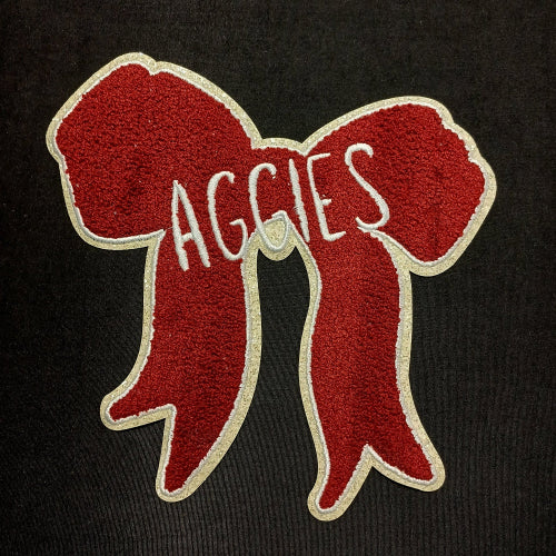 Red bow patch with 'AGGIES' text on a black background